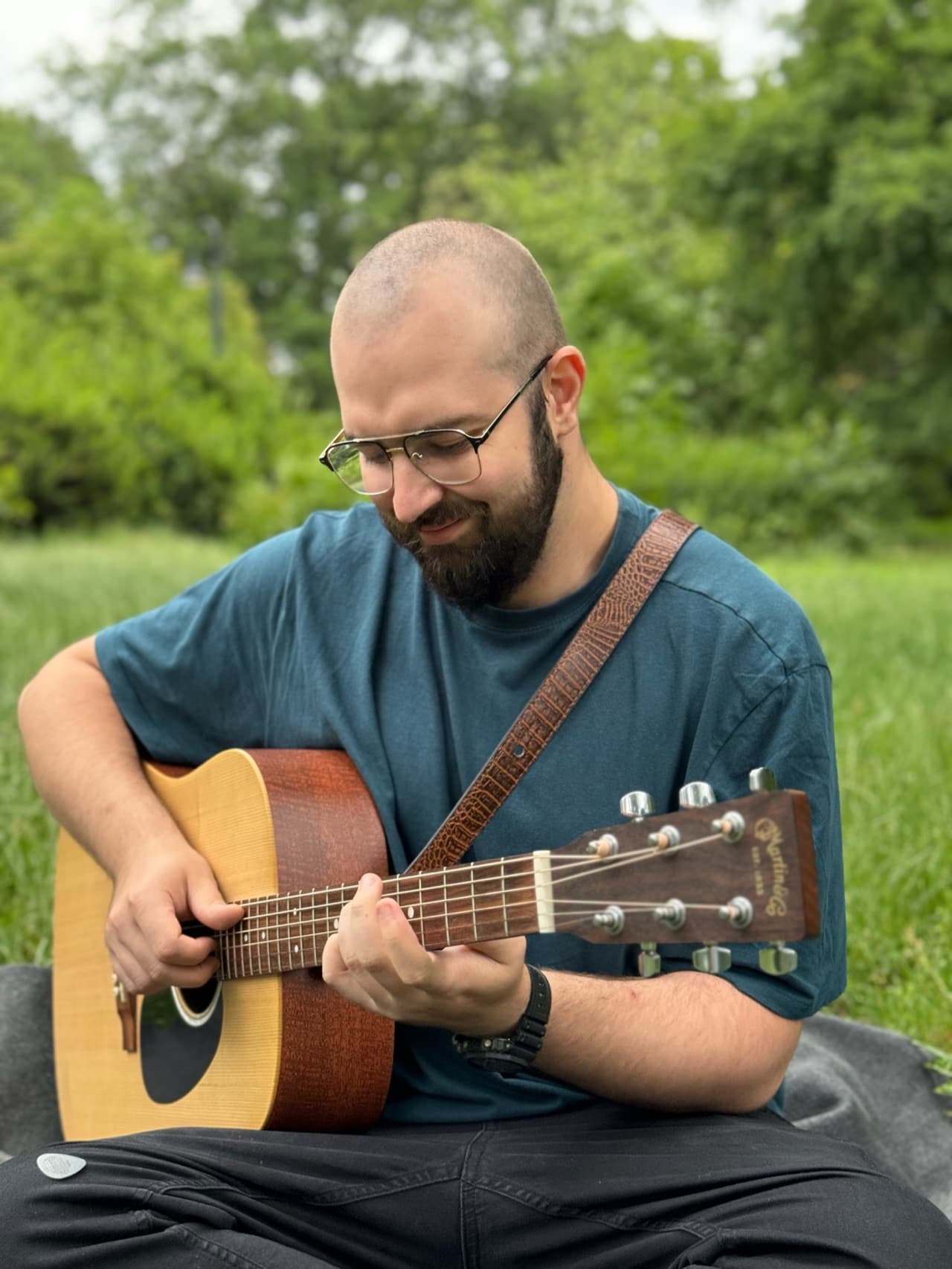Piotr, Strummy's founder, playing acoustic guitar in a park
